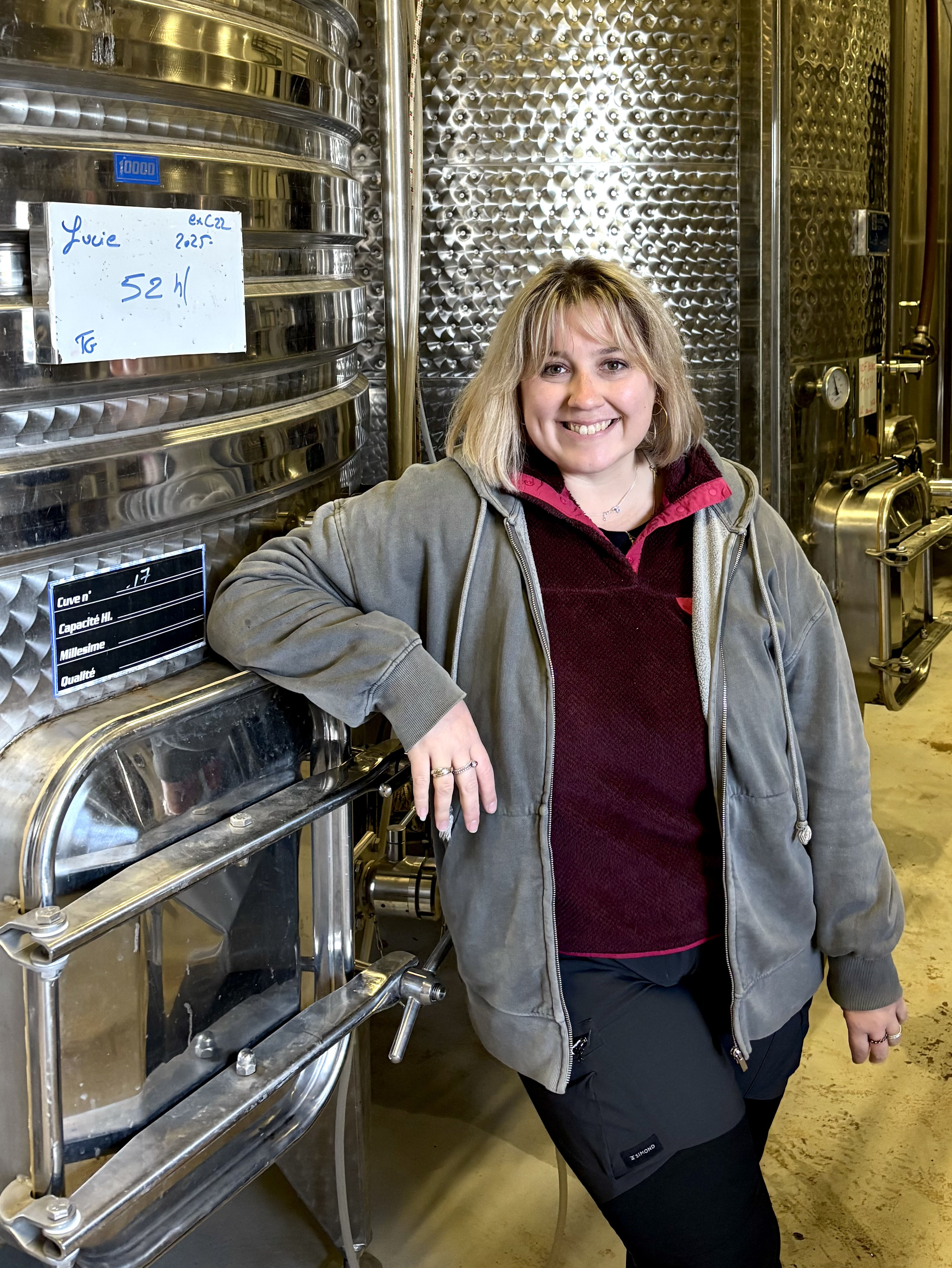 Une photo d'Ambre devant les cuves de la cave du domaine