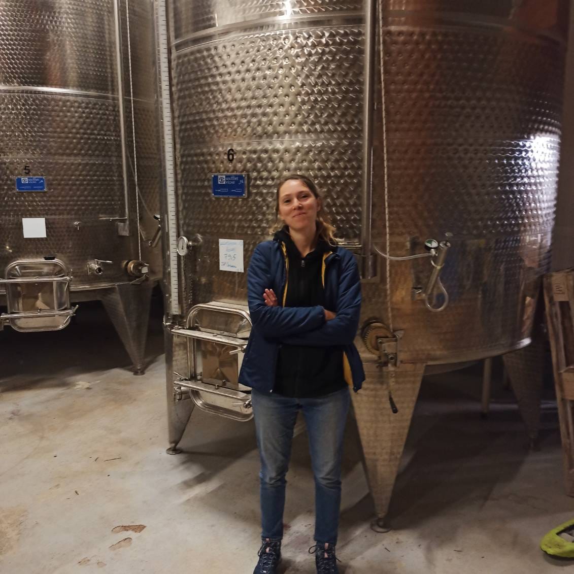 Une photo d'Hélène devant les cuves de la cave du domaine