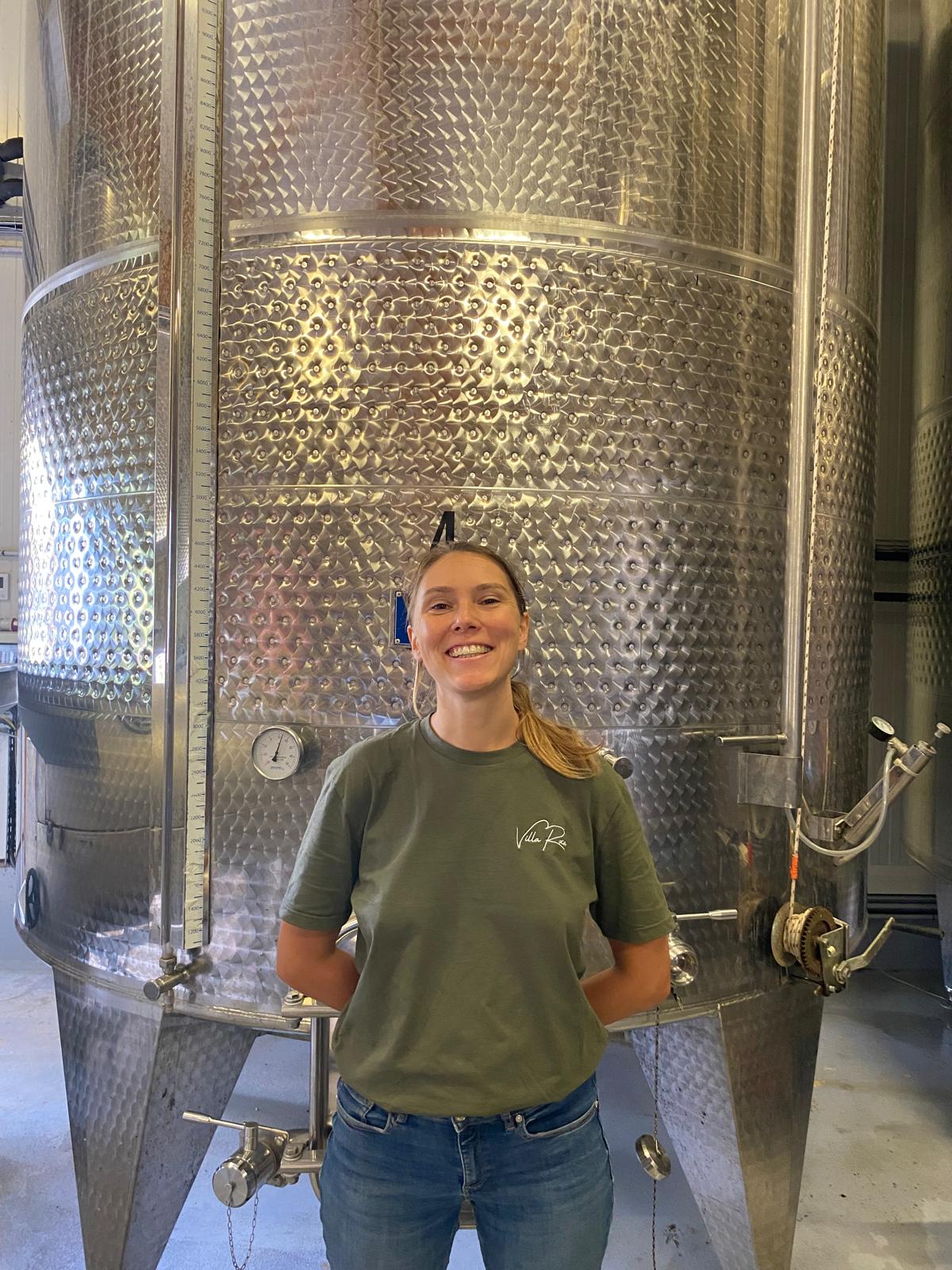 Photo of Hélène in front of the cellar tanks